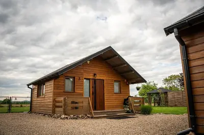 a small wooden cabin with a gambrel roof at Relax domki Zator in Zator