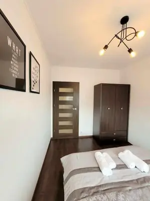 a bedroom with a bed with two pillows and a cabinet at Apartament Dark Chocolate 4 persons Down Town in Kraków