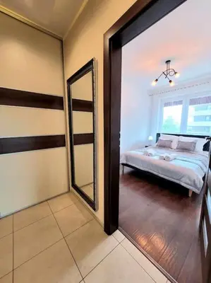 a bedroom with a bed and a mirror in it at Apartament Dark Chocolate 4 persons Down Town in Kraków