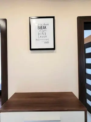 a picture on a white wall with a wooden table at Apartament Dark Chocolate 4 persons Down Town in Kraków