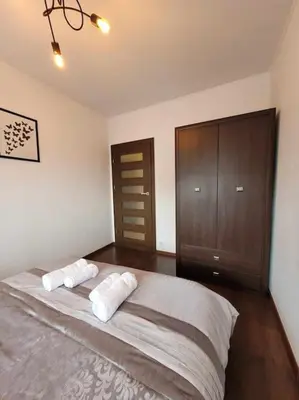 a bedroom with a large bed with two pillows at Apartament Dark Chocolate 4 persons Down Town in Kraków