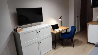 a room with a desk with a television and a table with a laptop at Apartament Xavier II Kraków in Kraków