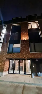a brick building with windows on a street at night at Apartament Xavier II Kraków in Kraków