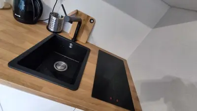 a kitchen counter with a sink with a phone on it at Apartament Xavier II Kraków in Kraków