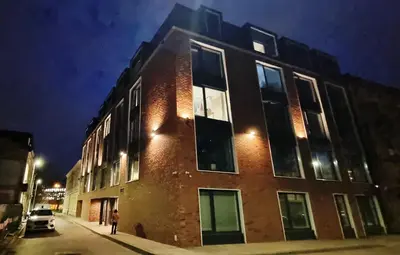 a brick building on a city street at night at Apartament Xavier II Kraków in Kraków