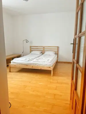 a bedroom with a bed and a wooden floor at Uroczy dom i bezpłatny parking in Mników