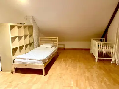 a small bedroom with a bed and a staircase at Uroczy dom i bezpłatny parking in Mników