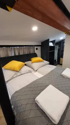 a large bed with white sheets and yellow pillows at Old Town Apartment, Starowiślna in Kraków