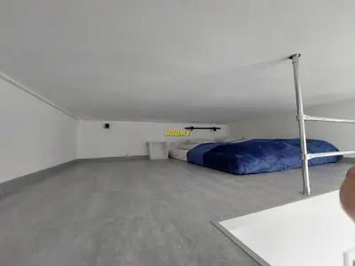 a bedroom with a bed in a room with a concrete floor at Old Town Stage The Studio Suite Quartet in Kraków