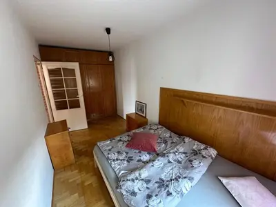 a bedroom with a bed with a wooden head board at Przestronny apartament w centrum miasta - Mszana M11 in Mszana Dolna