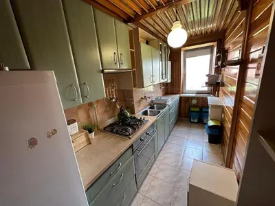 a kitchen with green cabinets and a refrigerator at Przestronny apartament w centrum miasta - Mszana M11 in Mszana Dolna