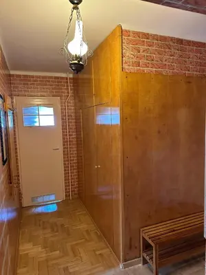 a room with a brick wall and a wooden cabinet at Przestronny apartament w centrum miasta - Mszana M11 in Mszana Dolna