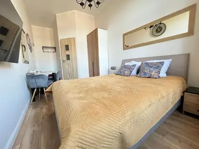 a bedroom with a large bed and a desk at Aparthotel Cracow in Kraków