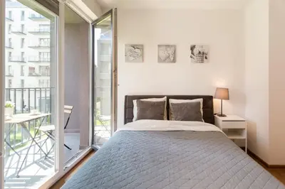 a bedroom with a bed and a large window at Perfect Stay Zabłocie 35 in Kraków