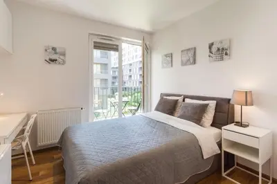 a bedroom with a bed and a desk and a window at Perfect Stay Zabłocie 35 in Kraków