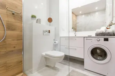 a bathroom with a toilet and a washing machine at Perfect Stay Zabłocie 35 in Kraków