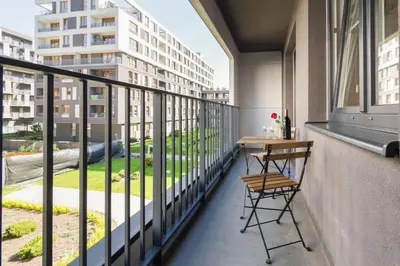 a balcony with a table and a view of a building at Perfect Stay Zabłocie 35 in Kraków