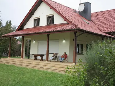 two people sitting on a porch of a house at AirSpot Balice in Cholerzyn