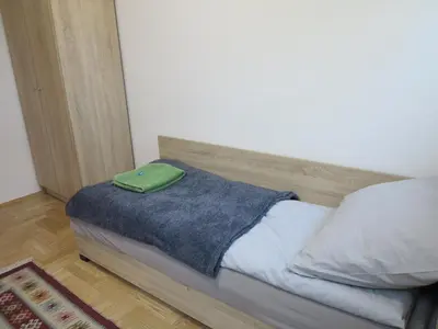a bed with a green bag on top of it at AirSpot Balice in Cholerzyn