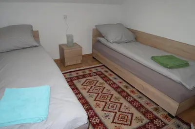 a bedroom with two beds and a rug at AirSpot Balice in Cholerzyn