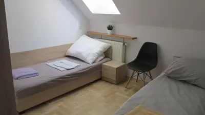 a small bedroom with a bed and a chair at AirSpot Balice in Cholerzyn