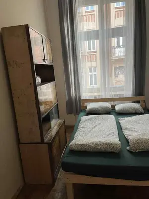 a bedroom with two beds in front of a window at Old Town Rooms Wielopole in Kraków
