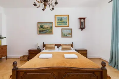 a bedroom with a large wooden bed with two pillows at Spacious Retro Apartment in the Center of Cracow by Noclegi Renters in Kraków