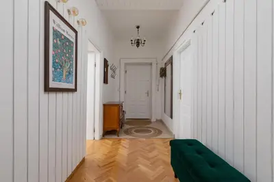 a hallway with white walls and a green couch at Spacious Retro Apartment in the Center of Cracow by Noclegi Renters in Kraków