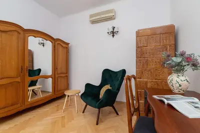 a living room with a table and chairs and a cabinet at Spacious Retro Apartment in the Center of Cracow by Noclegi Renters in Kraków