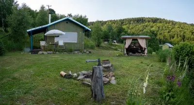 a backyard with a shed and a grill in the grass at RESETówka nr 1 - chatka na odludziu z mega widokami & leśne SPA in Jaszczurowa