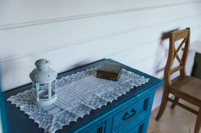 a blue dresser with a lantern on it with a chair at RESETówka nr 1 - chatka na odludziu z mega widokami & leśne SPA in Jaszczurowa