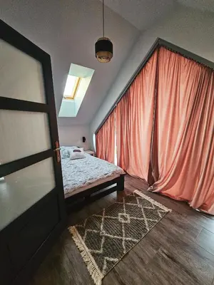 a bedroom with a bed and a red curtain at Cienista Dolina in Brzoskwinia