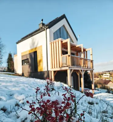 a house with snow on the ground in front of it at Cienista Dolina in Brzoskwinia