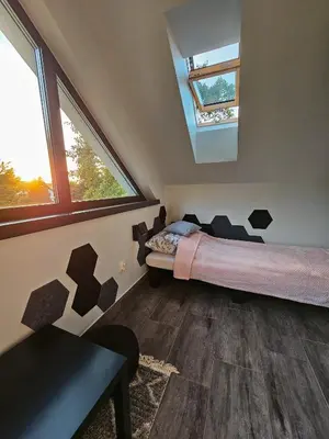 a bedroom with a bed in a room with windows at Cienista Dolina in Brzoskwinia