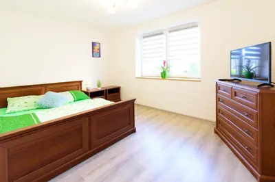 a bedroom with a large wooden bed and a dresser at Domek na wzgórzu in Sosnowice