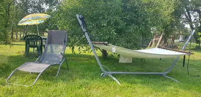 a hammock and a chair and an umbrella in the grass at Domek na wzgórzu in Sosnowice
