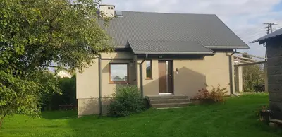 a small house with a grassy yard in front of it at Domek na wzgórzu in Sosnowice