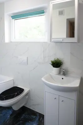 a white bathroom with a sink and a toilet at Domek na wzgórzu in Sosnowice