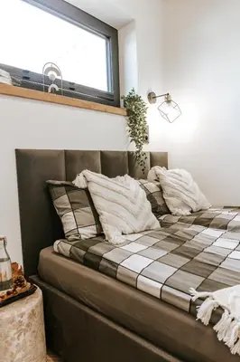 a bedroom with a bed with a plaid blanket at Domki Bliżej Natury z Jacuzzi in Rabka