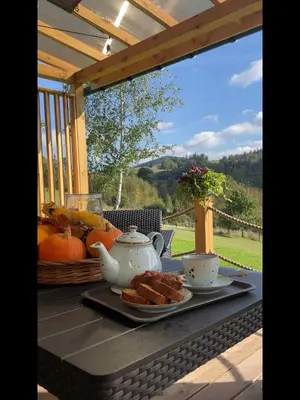 a table with a plate of food and a tea set at Domki Bliżej Natury z Jacuzzi in Rabka