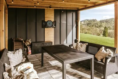 a screened in porch with a table and chairs at Domki Bliżej Natury z Jacuzzi in Rabka