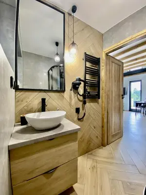 a bathroom with a sink and a mirror at Domki Bliżej Natury z Jacuzzi in Rabka