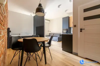 a kitchen and dining room with a table and chairs at Apartamenty Skawińska 10 in Kraków