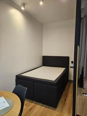 a small room with a bed and a table at Apartamenty Skawińska 10 in Kraków