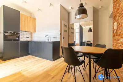 a kitchen and dining room with a table and chairs at Apartamenty Skawińska 10 in Kraków