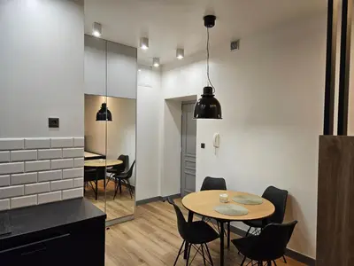 a kitchen and dining room with two tables and chairs at Apartamenty Skawińska 10 in Kraków