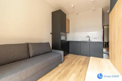 a living room with a couch and a kitchen at Apartamenty Skawińska 10 in Kraków
