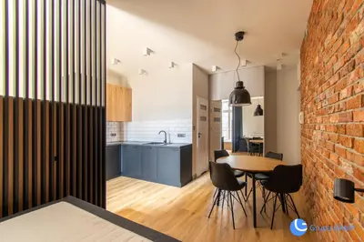 a kitchen and dining room with a brick wall at Apartamenty Skawińska 10 in Kraków