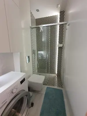 a bathroom with a shower and a washing machine at Z-1 Kraków Old Town O&P ApartFamily in Kraków