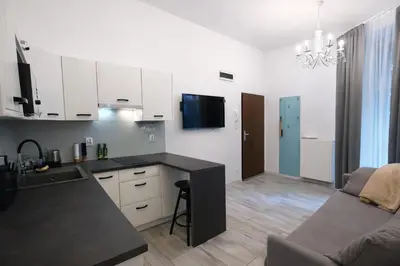 a kitchen with white cabinets and a black counter top at Z-1 Kraków Old Town O&P ApartFamily in Kraków